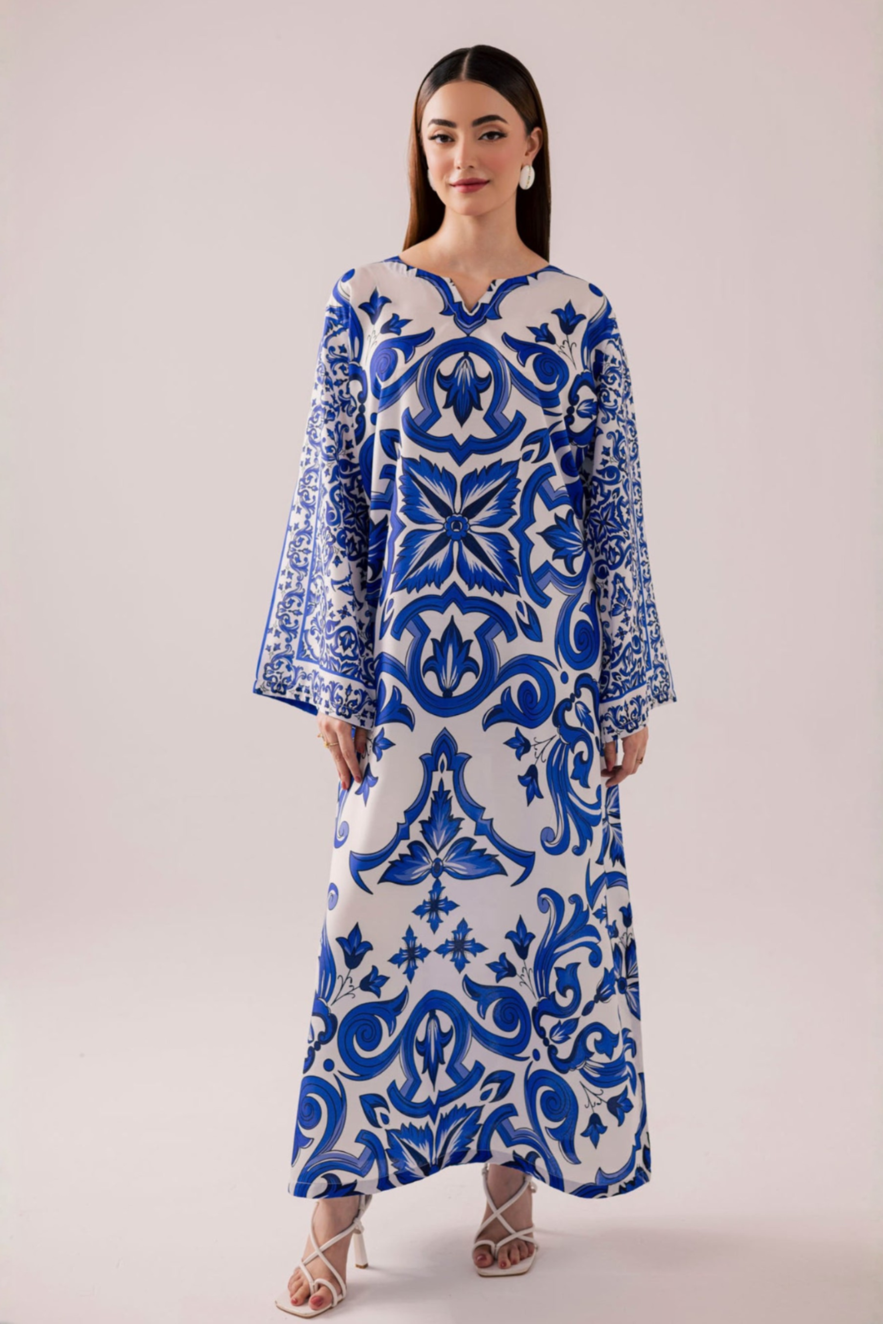 Woman wearing a blue and white patterned dress on a plain background